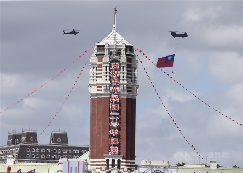 雙十國慶大會10日登場，國軍CH-47直升機吊掛歷年典禮最大、總長達18公尺、寬12公尺、重45公斤，攤開占地約65坪的國旗，飛越總統府上空。中央社記者郭日曉攝 110年10月10日