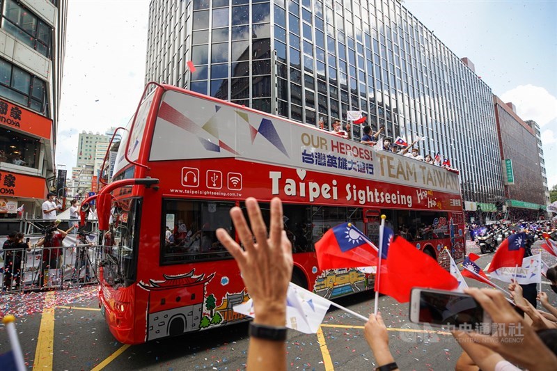 中華文化總會10日在台北舉行「OUR HEROES!台灣英雄大遊行」,邀請東京奧運及帕運的選手及代表隊成員參與車隊遊行,民眾揮舞國旗夾道歡迎。中央社記者裴禛攝 110年10月10日