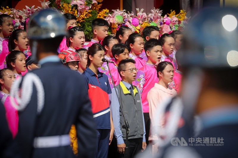 中華民國中樞暨各界慶祝110年國慶大會10日舉行,衛福部疾管署副署長羅一鈞(前中)、東奧銅牌得主羅嘉翎(前中左)等6人偕同國立客家兒童合唱團領唱國歌。中央社記者王騰毅攝 110年10月10日