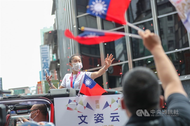 中華文化總會10日在台北舉行「OUR HEROES!台灣英雄大遊行」,邀請東京奧運及帕運的選手及代表隊成員參與車隊遊行,空手道選手文姿云(中)揮手向現場喝采民眾致意。中央社記者裴禛攝 110年10月10日