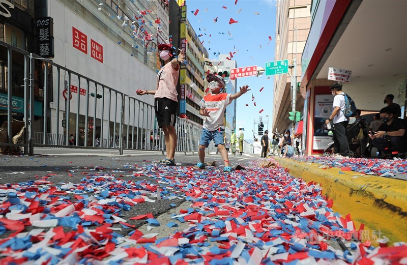 「OUR HEROES!台灣英雄大遊行」10日國慶日在台北舉行,遊行過程沿街撒下碎紙花為台灣英雄喝采,會後有家長與小朋友開心拋飛地上的繽紛紙花,留下美好回憶。中央社記者裴禛攝 110年10月10日