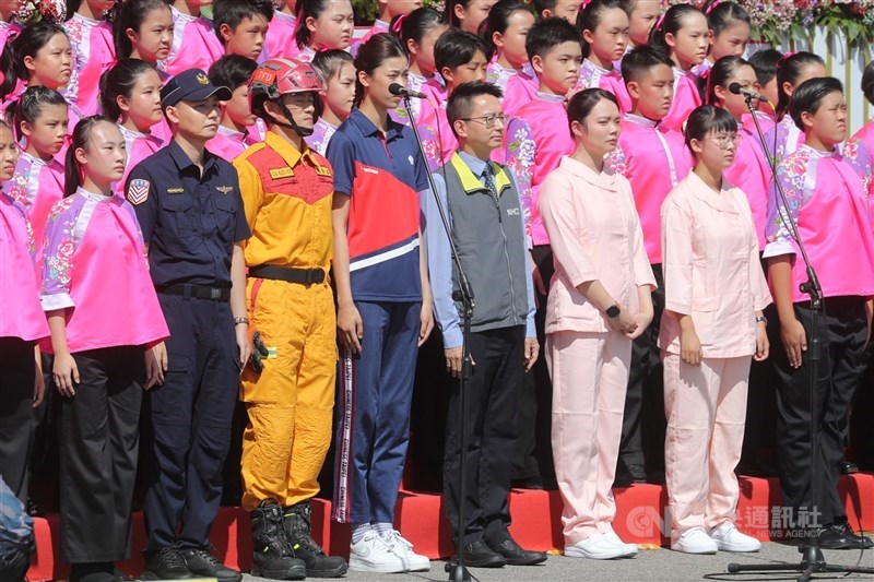 國慶大會10日登場,衛福部疾管署副署長羅一鈞(前右4)、東奧銅牌得主羅嘉翎(前左4)以及遭COVID-19確診者攻擊受傷的雙和醫院護理師陳昀湞(前右3)、施宜君(前右2)共同領唱國歌。中央社記者王騰毅攝 110年10月10日
