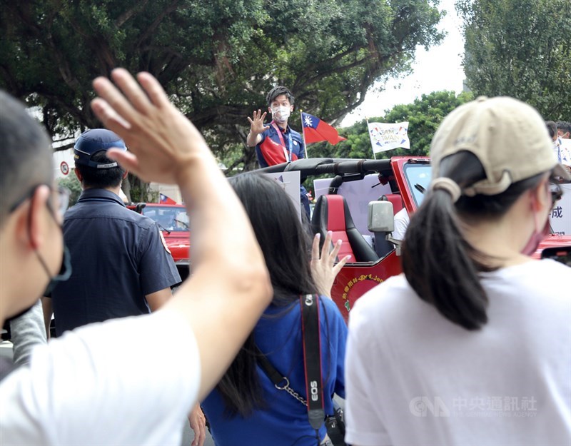 「OUR HEROES!台灣英雄大遊行」10日在國慶典禮後登場,體操選手李智凱(後中)在車隊上開心向民眾揮手致意。中央社記者張皓安攝 110年10月10日