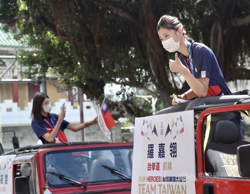「OUR HEROES!台灣英雄大遊行」10日在國慶典禮後登場,跆拳道選手羅嘉翎(右)在車隊上跟民眾打招呼。中央社記者張皓安攝 110年10月10日