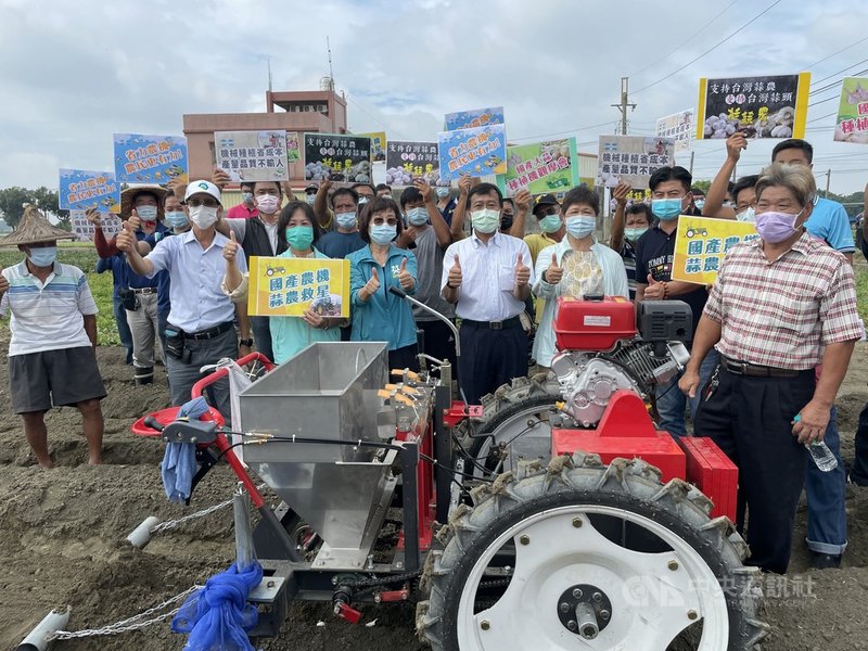 國產大蒜目前種植仍靠人力,不僅成本居高不下,更面臨人力老化、缺工等困境,農機業者花3年時間研發國產大蒜種植機,民進黨立委蘇治芬(前排左4)、農糧署中區分署長姚士源(前排左5)等人12日參加觀摩發表會,評論種植機的優缺點。中央社記者姜宜菁攝 110年10月12日