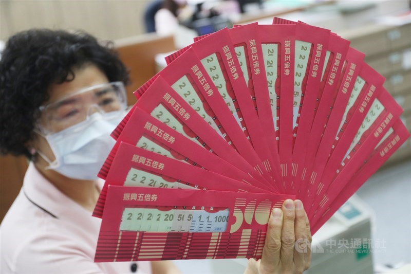 郵局12日開放振興五倍券紙本預約領券,民眾於開放領取期間需攜帶健保卡,依所選時段到預約的郵局領取五倍券。圖為郵局工作人員展示振興五倍券。中央社記者吳家昇攝 110年10月12日