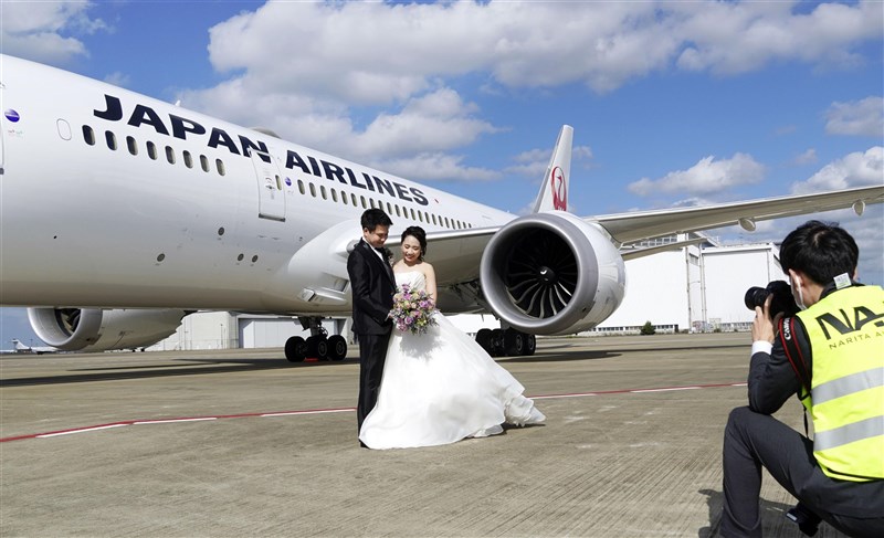 疫情導致許多新人延期辦婚禮或蜜月旅行,日本成田機場推出讓新人在停機坪與飛機一起拍婚紗照的服務。(共同社)