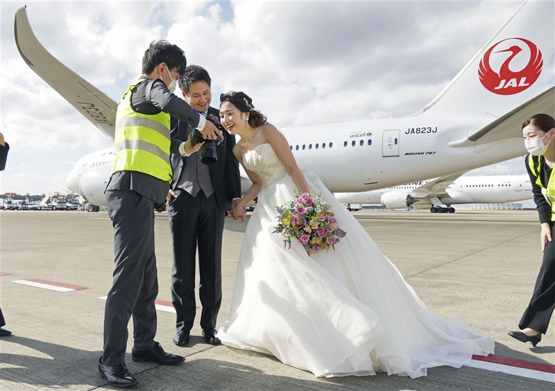 日本成田機場推出讓新人在停機坪與飛機一起拍婚紗照的服務,費用包含服裝等為37萬1000日圓(約新台幣9萬3000元)起。(共同社)