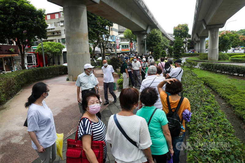花博接種站13日開打68歲以上長者第2劑莫德納疫苗,因人潮眾多又是下雨天,許多長輩、陪打民眾雨中排隊等候。中央社記者吳家昇攝 110年10月13日