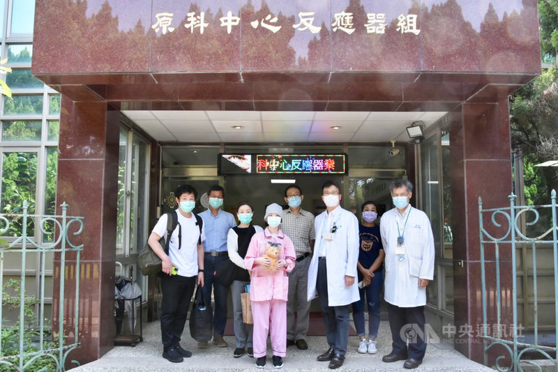 罹患惡性腦瘤的20歲日本女子(前中)在國立清華大學硼中子捕獲治療中心的療程結束後,醫療團隊送上戴畢業方帽的小熊,祝福她能在抗癌路上「畢業」、完全康復。(清大提供)中央社記者魯鋼駿傳真 110年10月14日