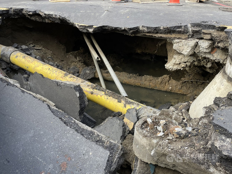 新北市三重區福德北路、長元街口15日下午發生塌陷,路面出現一個大坑洞,經區公所調度開挖,初步研判是側溝破損導致淘空,目前已調派機具進行灌漿、回填地基。(新北市工務局提供)中央社記者沈佩瑤新北市傳真 110年10月15日