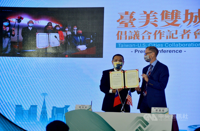 在美國在台協會(AIT)商務組長歐德瑞(Brent Omdahl)(右)見證下,新北市長侯友宜(左)15日與美國古柏迪諾市市長保羅(Darcy Paul)簽署合作意向書,未來將共同推動兩座城市教育、經濟、文化交流。中央社記者黃旭昇新北攝 110年10月15日