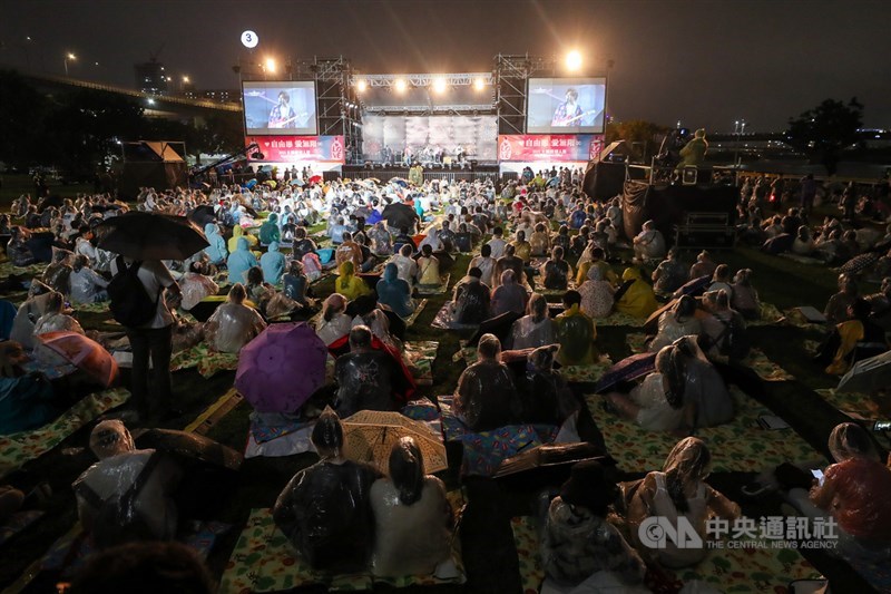 「2021大稻埕情人節」活動配合防疫採預約抽籤制,16日晚間登場,儘管傍晚開始下起陣雨,幸運中籤民眾仍是冒雨到場觀看精彩表演。中央社記者裴禛攝 110年10月16日