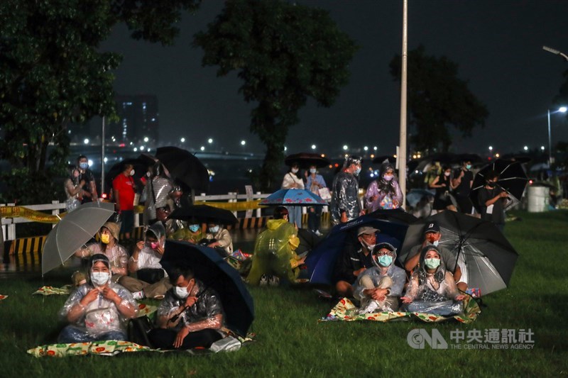 「2021大稻埕情人節」活動16日晚間登場,儘管傍晚開始下起陣雨,仍有不少民眾不畏風雨在河岸旁卡位,等候絢麗煙火升空。中央社記者裴禛攝 110年10月16日