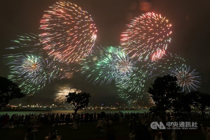 「2021大稻埕情人節」活動重頭戲、精彩煙火秀16日晚間雨中登場,熱情民眾不畏風雨,在河岸邊開心欣賞璀璨煙花點亮夜空。中央社記者裴禛攝 110年10月16日