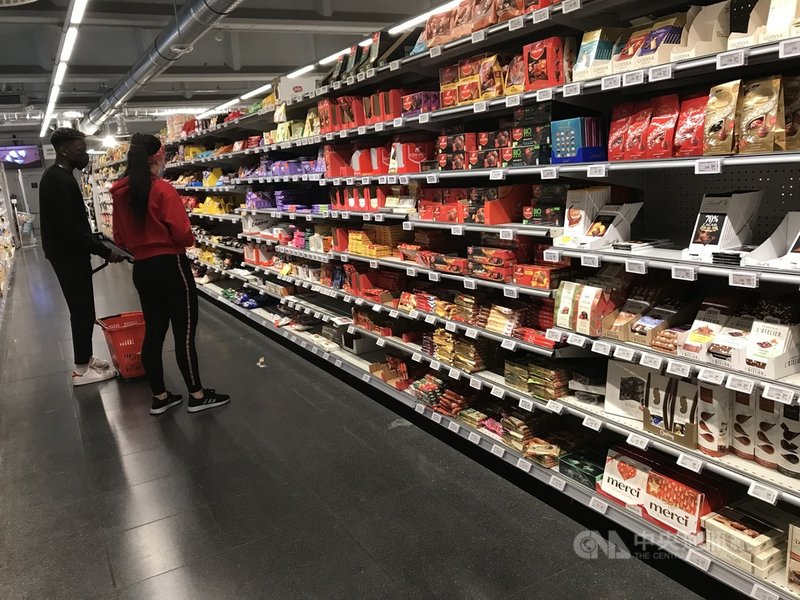 布魯塞爾連鎖超市巧克力區品項繁多,直接一整列任君挑選,圖為2021年10月19日一家超市裡顧客正在選購巧克力。中央社記者唐佩君布魯塞爾攝 110年10月20日