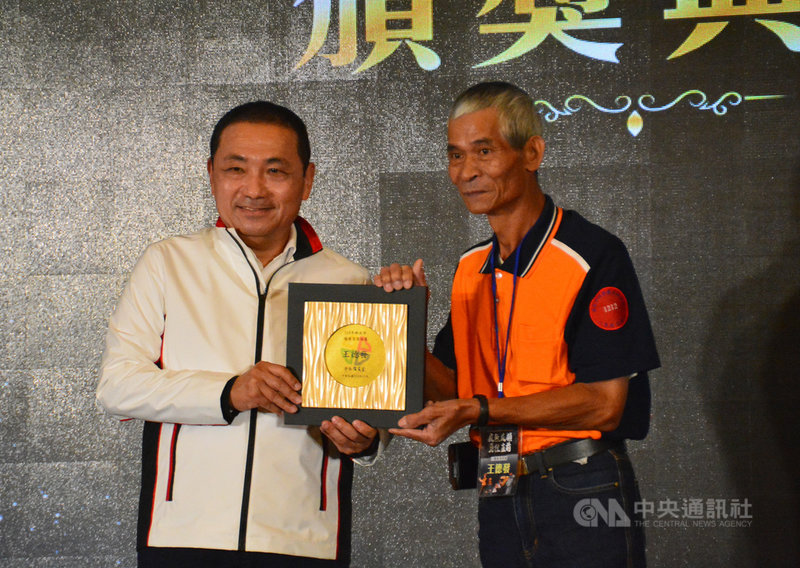 新北市環保局21日頒獎表揚年度績優清潔人員、績優職安衛管理人員及績優交通安全管理人員,市長侯友宜(左)親自到場頒獎,感謝清潔隊員整年辛勞。中央社記者黃旭昇新北市攝 110年10月21日