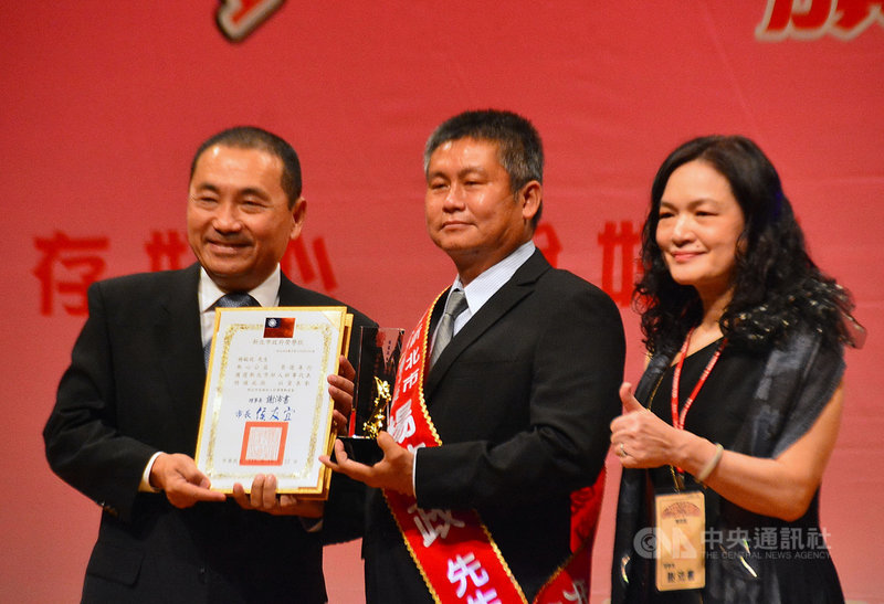 新北市急難救援協會大隊長楊敏政(中)投身救難服務多年,日前也在虎豹潭落水搜救行動中運用空中和水下無人機提供協助,22日獲新北市長侯友宜(左)頒發110年度新北好人好事代表證書及獎座表揚。中央社記者黃旭昇新北市攝 110年10月22日