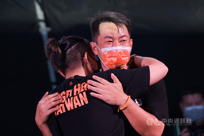 台灣基進立委陳柏惟(右)罷免案通過,23日晚間陳柏惟到開票現場向支持者致意,民眾獻上溫暖擁抱打氣。他受訪時說,「我不覺得是輸,我們還有很長的時間,下一戰再贏回來。」中央社記者裴禛攝 110年10月23日