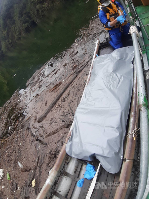李姓登山客日前到台中市和平區登山,回程橫渡大甲溪與有勝溪匯流處時不慎遭沖走,搜救人員23日在案發處下游26公里處、德基水庫漂流木匯集地發現李男遺體,打撈上岸後交由警方進行後續調查釐清。(台中市消防局提供)中央社記者蘇木春傳真 110年10月23日