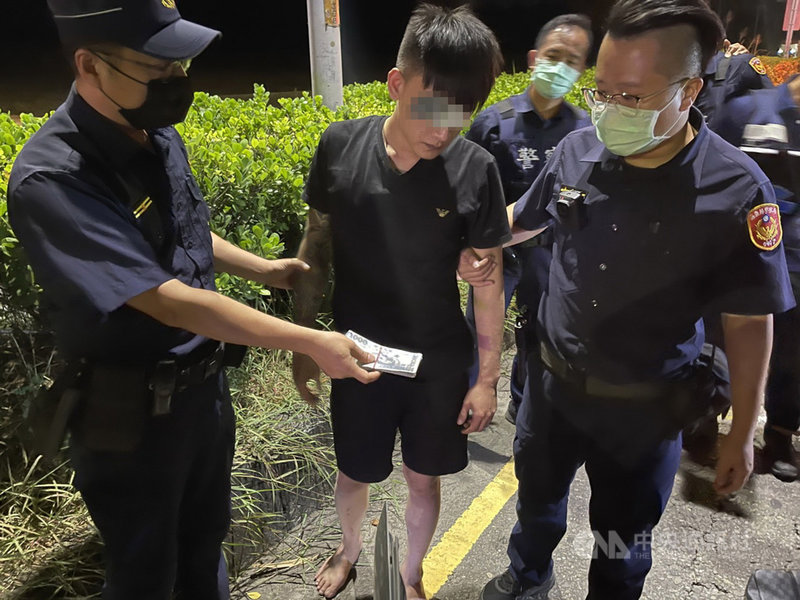 楊姓男子(中)25日晚間開車在嘉義縣民雄鄉自撞分隔島翻車,肇因24日曾用假鈔加油,誤以為警方在追緝他,心虛開車逃逸,卻翻車被逮捕,警方在車上起出85張偽鈔。(讀者提供)中央社記者蔡智明傳真 110年10月25日