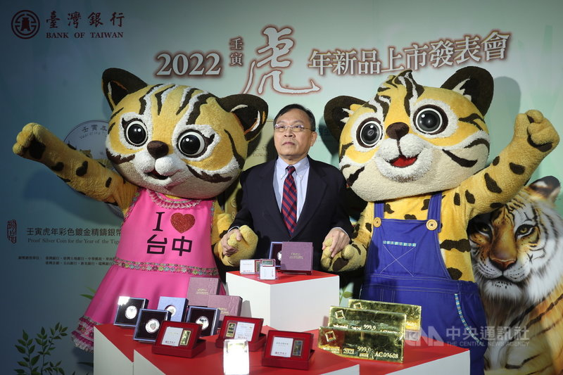 台灣銀行26日舉辦2022壬寅虎年新品上市發表會,宣布發行「壬寅虎年彩色鍍金精鑄銀幣」及「台銀金鑽條塊虎年生肖版」。台銀董事長呂桔誠(中)展示銀幣及金條。中央社記者吳家昇攝 110年10月26日