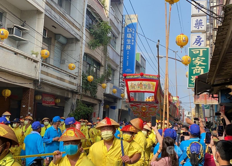 屏東東港東隆宮迎王平安祭30日下午進行遷船遶境儀式,王船在鎮內遶境,現場工作人員於王船行經前,會先以竹竿撐起電線,好讓王船順利通過。中央社記者郭芷瑄攝 110年10月30日