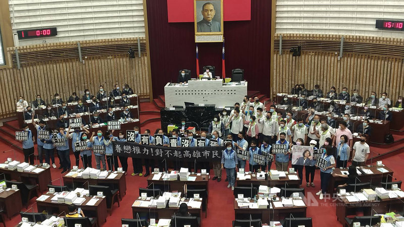 高雄市政府111年度總預算4日交付議會審查,國民黨團議員在議事廳高舉布條、標語,喊出「沒有負責、沒有預算」;民進黨團議員則同場高呼「綁架預算,犧牲市民」等口號,雙方人馬場中對峙。中央社記者蔡孟妤攝 110年11月4日