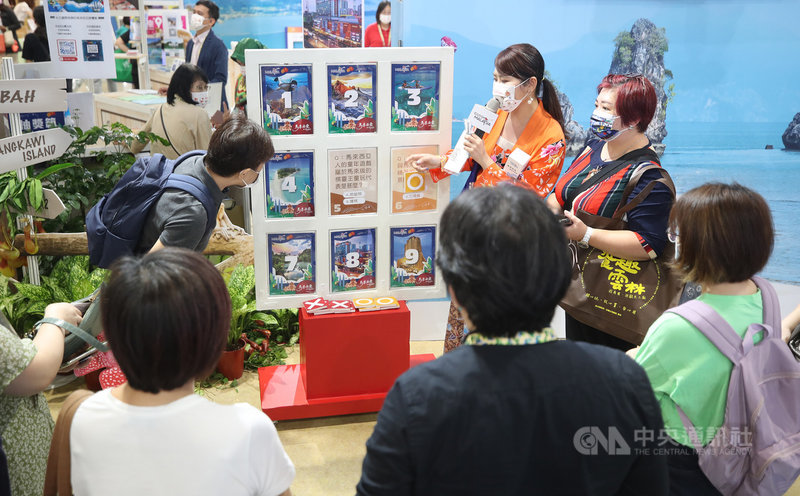 2021 ITF台北國際旅展5日起至8日在台北南港展覽館熱鬧登場,參展單位力拚疫後旅遊商機,馬來西亞主題館安排主持人與民眾玩小遊戲互動。中央社記者張新偉攝 110年11月5日