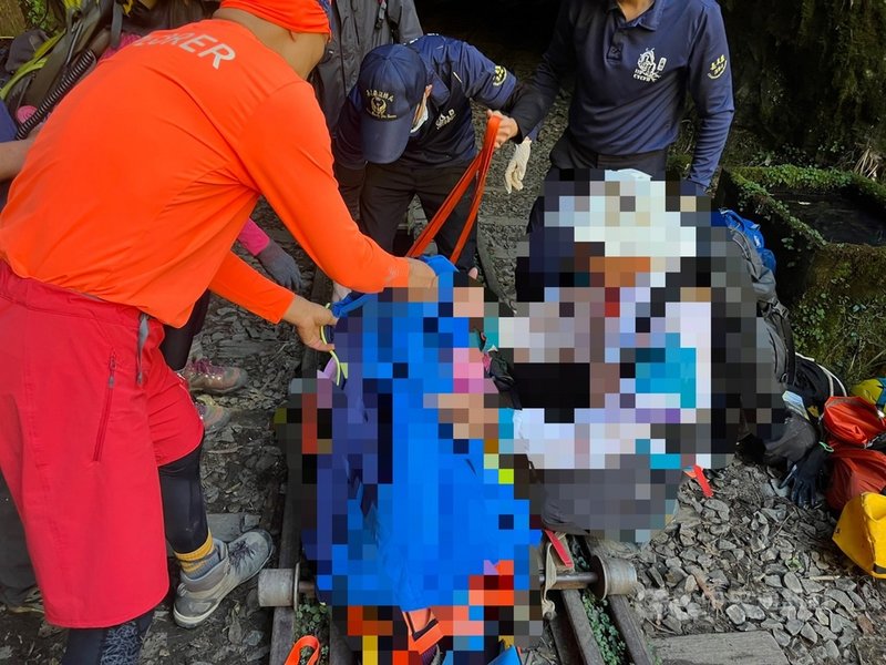 阿里山眠月線8日上午發生事故,一名年約54歲女性山友不慎跌落山谷,嘉義縣消防局會同員警等前往救援,將傷者從山谷吊掛上鐵道,並以簡易鐵道板車運送至救護車停放地點,送醫救治。(嘉義縣消防局提供)中央社記者蔡智明傳真 110年11月8日