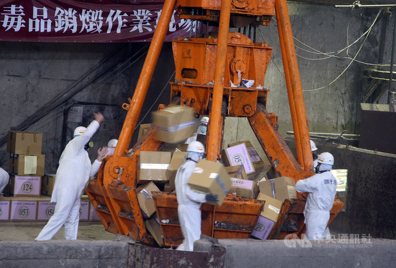 法務部調查局9日在木柵垃圾焚化廠辦理110年度第2次全國獲案毒品證物公開銷燬儀式,工作人員搬運獲案毒品證物,準備投入焚化爐內銷燬。中央社記者郭日曉攝 110年11月9日
