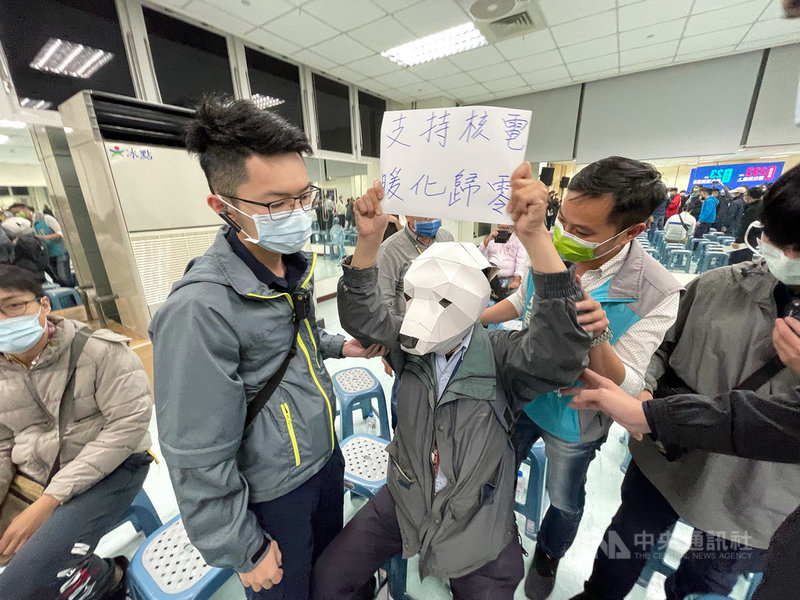 行政院長蘇貞昌11日晚間在台北市內湖區出席民進黨「四個不同意 台灣更有力」公投說明會,不過有立場相反民眾在台下高舉標語表達訴求,現場工作人員也上前關切。中央社記者王飛華攝 110年11月11日