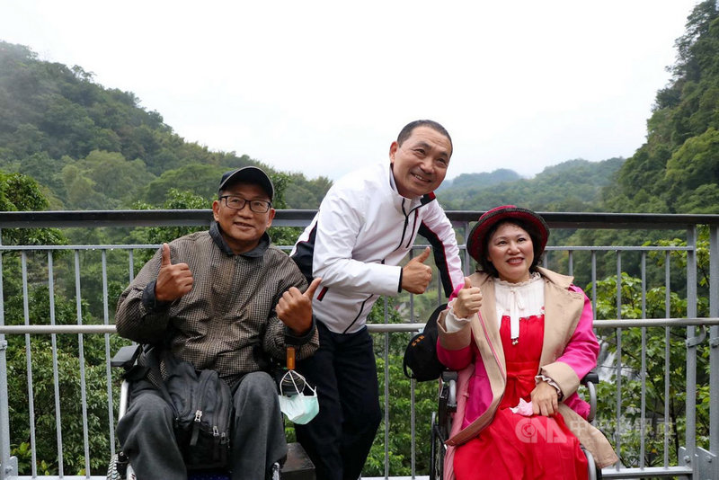 通往新北市平溪區十分瀑布園區的友善步道13日開通,台灣無障礙旅遊發展協會秘書長周文章(左)、理事長鄭淑勻(右)與新北市長侯友宜(中)到場體驗,並於觀景台開心留影。(新北市觀旅局提供)中央社記者黃旭昇新北市傳真 110年11月13日