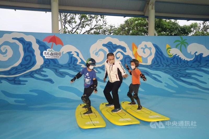 新北市金山區中角灣擁有獨特地形,成衝浪勝地,全國首座「衝浪運動教育園區」13日啟用,新北市長侯友宜(中)下場和小朋友一起體驗陸上衝浪練習。(新北市教育局提供)中央社記者沈佩瑤傳真 110年11月13日