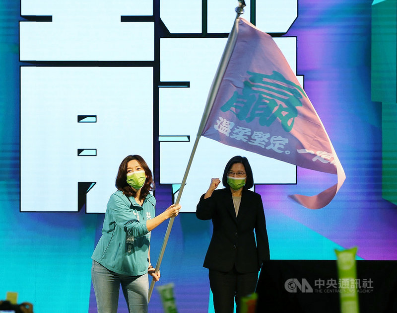 民進黨全代會14日下午在台北國際會議中心舉行,身兼黨主席的總統蔡英文(右)授戰旗給台中市第2選區立委補選提名人林靜儀(左),並一同呼口號加油。中央社記者郭日曉攝 110年11月14日