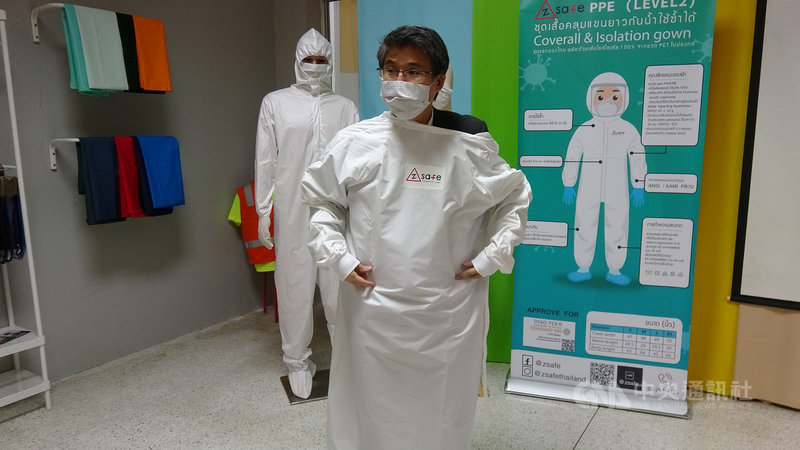 位於泰國羅勇的興懋(Thai Taffeta)工廠將回收寶特瓶製成的線紗織布,再做成給醫護人員使用的防護衣,圖為興懋第二代接班人賴建明示範穿脫防護衣。中央社記者呂欣憓羅勇府攝 110年11月15日