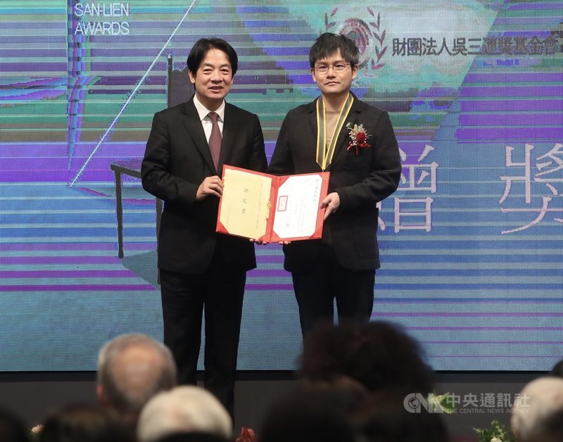 副總統賴清德(左)15日下午在台北出席「第42屆吳三連獎贈獎典禮」,頒獎給得獎人鄭亦煦(伊格言)(右)。中央社記者吳家昇攝 110年11月15日