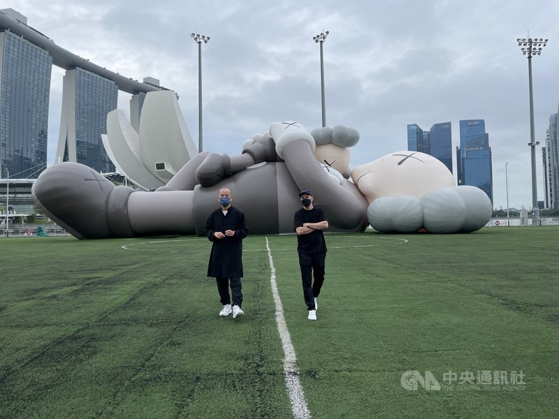 KAWS:HOLIDAY世界巡迴展覽最新一站前進新加坡,展出全長42公尺的巨型充氣公仔雕塑,藝術家KAWS(右)也隨著作品首度訪問星國。攝於13日。 中央社記者侯姿瑩新加坡攝 110年11月16日