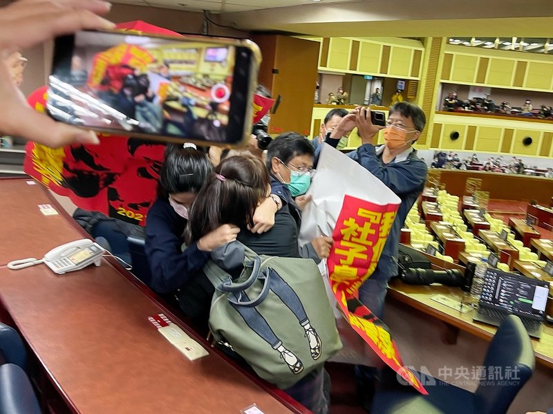 台北市長柯文哲19日至市議會接受市政總質詢,中途遭社子島自救會成員持海報闖進媒體席,高喊口號抗議,警衛上前攔阻,雙方發生拉扯衝突。中央社記者郭日曉攝 110年11月19日