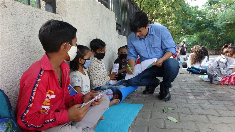印度非政府組織「塔林」(Taleem,教育之意)透過在路邊上課的方式,為失學兒童提供非正式教育,並鼓勵他們重返學校。圖為塔林負責人阿斯坦納(Saurabh Asthana)指導小朋友學業。中央社記者林行健德里攝 110年11月20日