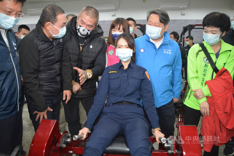 新北市政府警察局體訓中心23日揭牌成立,成吉思汗健身房負責人「館長」陳之漢(前左3)捐贈健身器材,並向新北市長侯友宜(前左2)說明男女員警要如何使用健身器材、如何暖身不受傷。中央社記者黃旭昇新北攝 110年11月23日