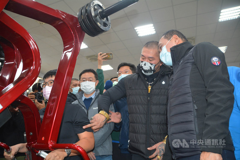 新北市政府警察局體訓中心23日揭牌成立,成吉思汗健身房負責人「館長」陳之漢(右2)捐贈健身器材,感謝警察對治安的付出。陳之漢並向新北市長侯友宜(右)等人說明器材使用方式。中央社記者黃旭昇新北攝 110年11月23日