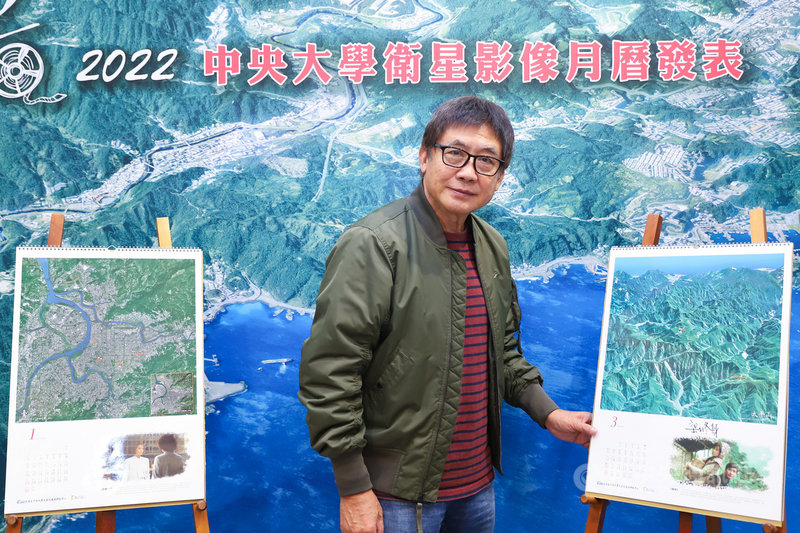 國立中央大學24日上午舉行2022衛星影像月曆發表記者會,知名導演梁修身出席,與電影「春寒」當年取景地空照圖合影。中央社實習記者蕭宇軒攝 110年11月24日