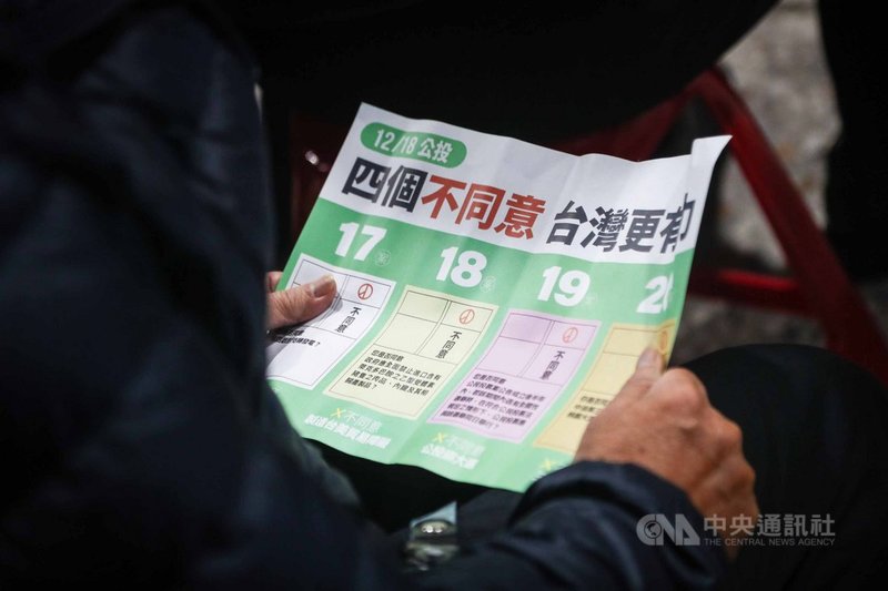 新北市議員陳世榮24日在新北市樹林區鎮南宮舉辦「四個不同意 台灣更有力」公投說明會,與會民眾仔細閱讀文宣關注公投案4大議題。中央社記者王騰毅攝 110年11月24日