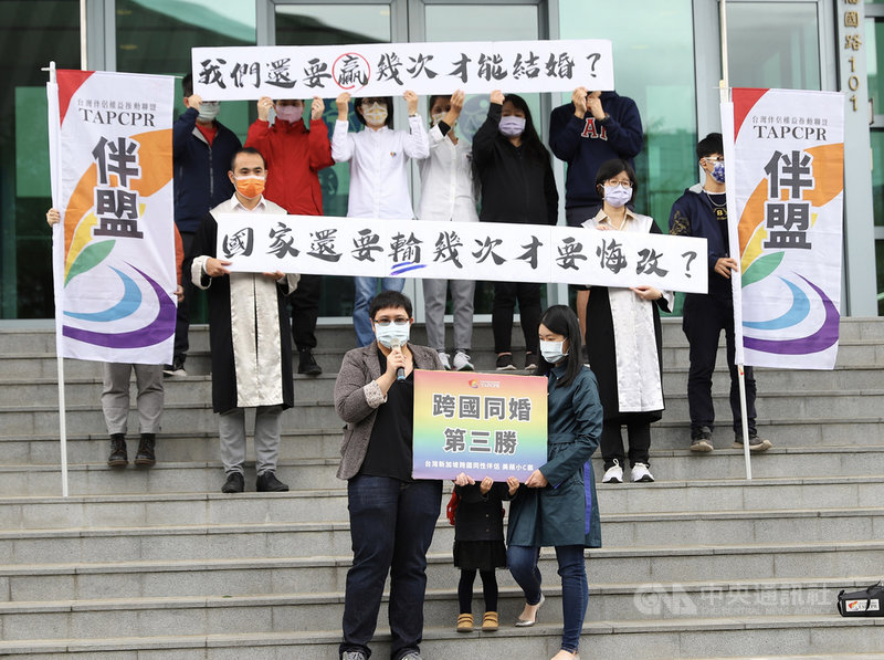台北高等行政法院25日上午宣判台灣女子小C(前右)與新加坡同志伴侶美蘋(前左)跨國同婚案勝訴,撤銷拒絕登記處分,戶政機關須准許申請。中央社實習記者蕭宇軒攝 110年11月25日