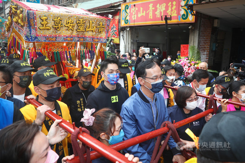 國民黨主席朱立倫(前藍衣者)與黨籍立委蔣萬安(中藍色口罩者)25日一同前往台北萬華艋舺青山宮參拜祈福,並參與扶轎遶境活動,場面熱鬧。中央社記者王騰毅攝 110年11月25日