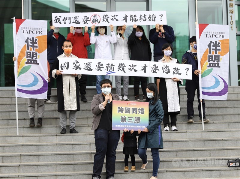 台北高等行政法院25日上午宣判台灣女子小C(前右)與新加坡同志伴侶美蘋(前左)跨國同婚案勝訴,撤銷拒絕登記處分,戶政機關須准許申請。中央社實習記者蕭宇軒攝 110年11月25日