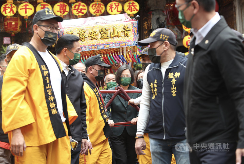 總統蔡英文(中)26日上午出席「艋舺青山王祭起駕儀式」,祈求國泰民安,並擔任扶轎官,送轎遶境。中央社記者吳家昇攝 110年11月26日