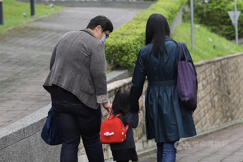 台北高等行政法院25日上午宣判台灣女子小C(右)與新加坡同志伴侶美蘋(左)跨國同婚案勝訴,戶政機關須准許申請。圖為小C、美蘋帶著幼女出庭。中央社實習記者蕭宇軒攝 110年11月25日