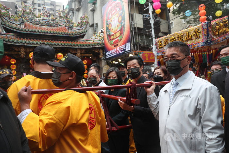 總統蔡英文(中)26日上午出席「艋舺青山王祭起駕儀式」,並擔任扶轎官,在良辰吉時送轎遶境,內政部長徐國勇(右1)、無黨籍立委林昶佐(右2)也到場。中央社記者吳家昇攝 110年11月26日